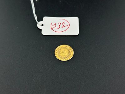 un gros plan d'une pièce d'or sur laquelle est accrochée une étiquette