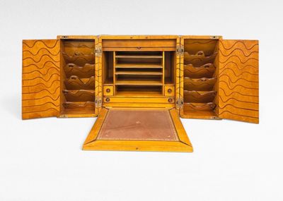 a small wooden box with a door open on a white surface