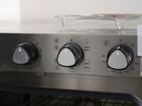 an image of a close up of a stove with a sign on it