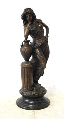 bronze statue of a woman with a vase on a pedestal