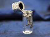 a glass jar with a silver object in it on a blue cloth