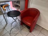 a red chair and a black stool in a kitchen