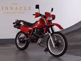 a red motorcycle parked in front of the pinnacle collection sign