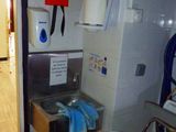 un lavabo dans une salle de bains avec un distributeur de serviettes fixé au mur