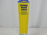un tube de dentifrice posé sur une table blanche