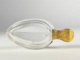 an image of a glass bottle with a gold handle on a white surface