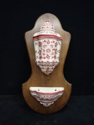 un vase fixé au mur et un bol posé sur un socle en bois