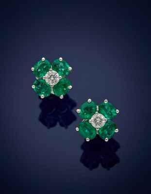 a pair of emerald and diamond earrings