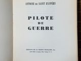 un livre ouvert posé sur une table en bois, avec une photo en noir et blanc
