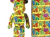 un ours jaune orné d'un motif graffiti coloré, à côté d'une boîte contenant un ours en peluche