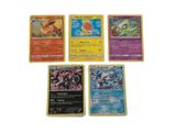 plusieurs cartes Pokémon empilées les unes sur les autres sur une surface blanche