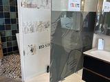une salle de bains avec une porte de douche en verre et un lavabo