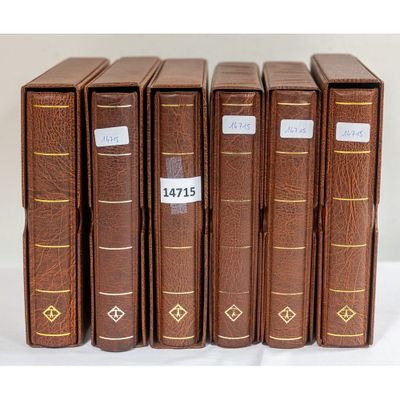 six livres marron sont alignés sur une surface blanche