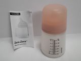 a bottle with a pink cap next to a packet of breast milk