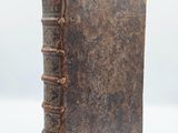 an old book sitting on top of a white surface
