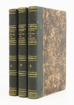 trois livres superposés sur une surface blanche