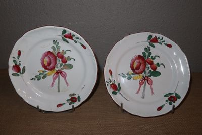 deux assiettes avec des fleurs peintes dessus, posées sur une table