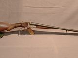 an old gun with a wooden barrel on a stand on a white background