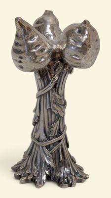 un vase en argent surmonté de deux oiseaux