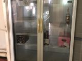 a refrigerator with two glass doors in a kitchen