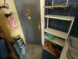a small bathroom with a sink and shelves in it
