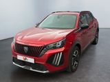 Le SUV rouge est garé dans une pièce au sol noir.