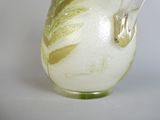 a glass vase with a bird on it sitting on a table