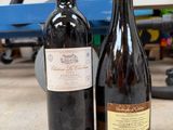 two bottles of wine sitting next to each other on the floor