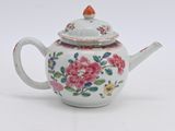 une théière blanche ornée d'un motif de fleurs roses
