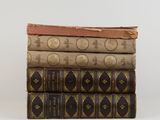three books stacked on top of each other on a white surface