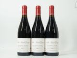 trois bouteilles de vin rouge posées sur une table blanche