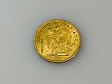 a close up of a gold coin on a white surface
