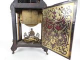 a clock that is sitting on a stand with a clock inside of it