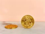 a gold coin sitting on top of a marble counter next to a gold coin