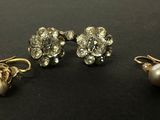 trois paires de boucles d'oreilles et une perle sur un fond noir