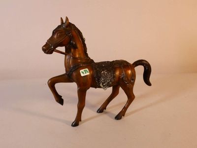 a small toy horse that is standing on a white surface