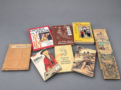 several books are arranged on a gray surface with a gray background