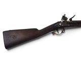 un vieux fusil avec un canon en bois et des garnitures en laiton