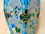 un vase bleu orné d'oiseaux et de fleurs