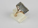 an image of a gold ring with a blue topazte stone