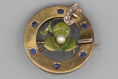 une image représentant une broche en or ornée d'une perle et de saphirs bleus