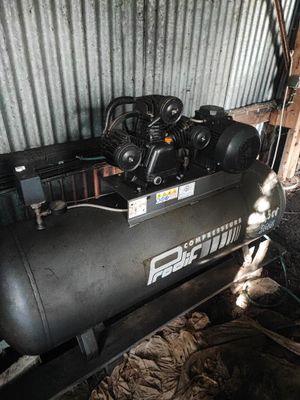 un compresseur d'air noir posé dans un garage