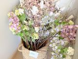 un panier de fleurs posé sur une étagère près d'un mur