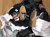 une boîte en carton remplie de vêtements et d'une paire de chaussures