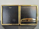 a black and gold case with a gold ring inside of it