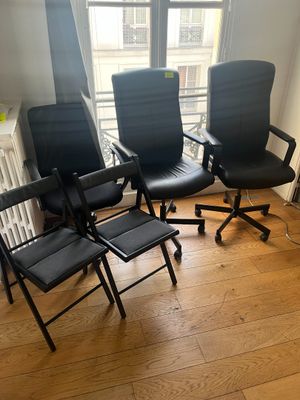 quatre chaises de bureau noires dans une pièce dotée d'une fenêtre et d'un radiateur