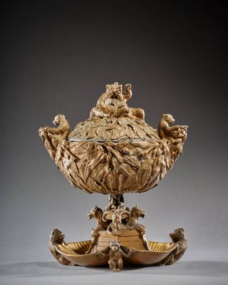 un bol richement sculpté, orné de figures, posé sur un socle
