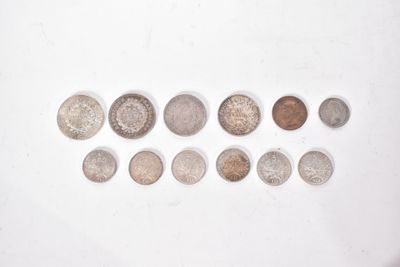 several different coins are arranged in a row on a white surface