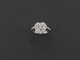 une bague en or blanc et diamants posée sur un fond noir