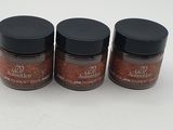 three jars of spices sitting on top of a white surface